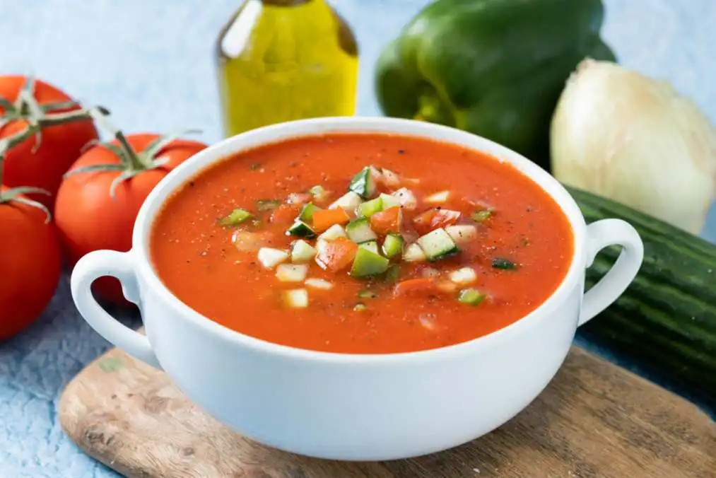 Cuenco de sopa tradicional española de gazpacho sobre fondo azul escala 1
